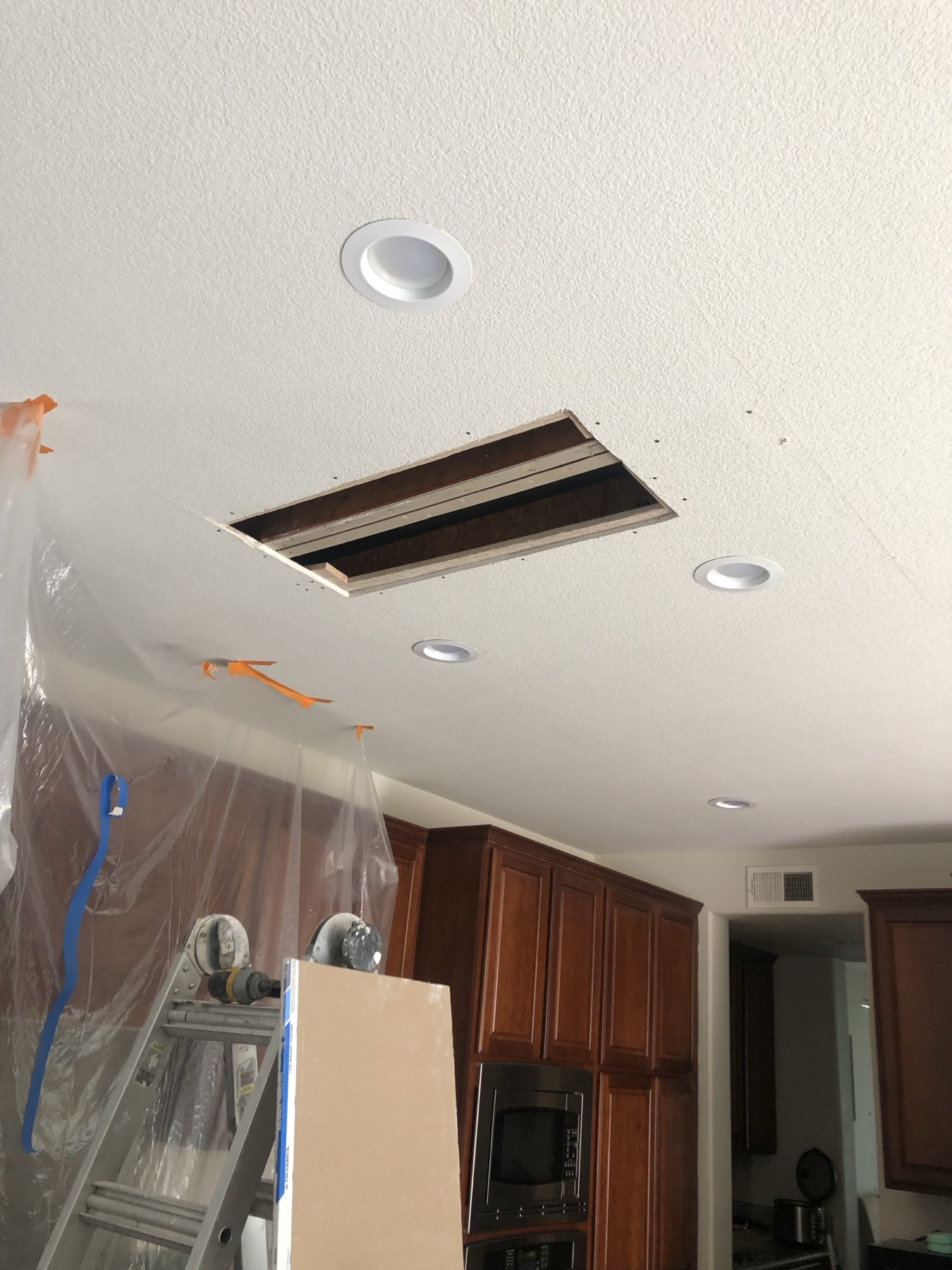 Close view of the opening in a kitchen ceiling between two recessed lights